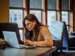 一个学生坐在笔记本电脑前努力学习.